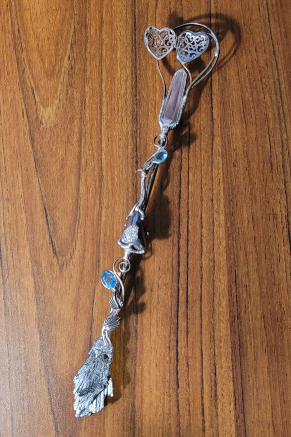 A crystal wand made with metal and crystals.